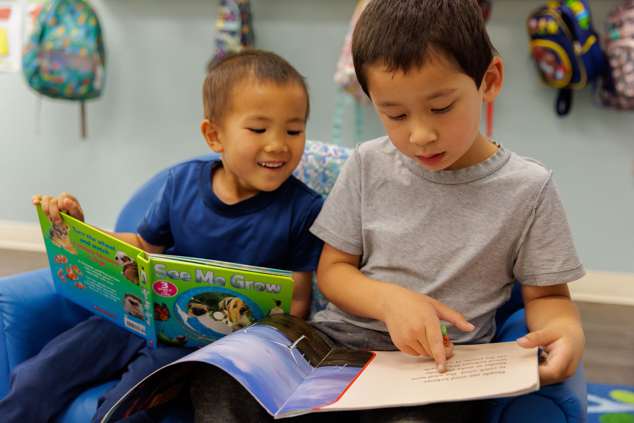 How to Help Children Learn to Love Reading Two children sitting next to each other reading books together